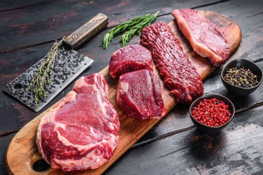 Çiğ sığır fileto fileto fileto, pirzola, striploin veya New York, etek, pala çeşitleri. Ahşap arka plan. Üst görünüm.