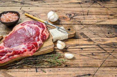 Pirzola ya da kovboy bifteği. Çiğ mermer sığır eti, siyah Angus, pirzola. Ahşap arka plan. Üst Manzara. Boşluğu kopyala.