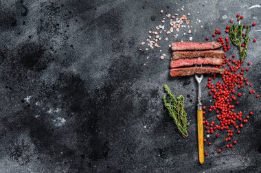 Baharatlı ızgara kaburga bifteği. Barbekü bifteği. Siyah arka plan. Üst Manzara. Boşluğu kopyala.