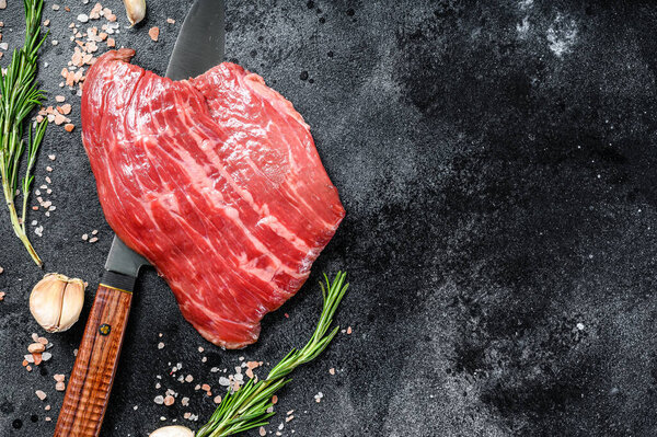 Raw Flat Iron steak black Angus. Fresh Marble beef meat. Black background. Top view. Copy space.
