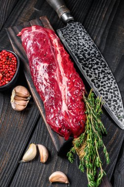 Çiğ Onglet Asma Tender biftek ahşap kesim tahtasında. Siyah ahşap arka plan. Üst görünüm.