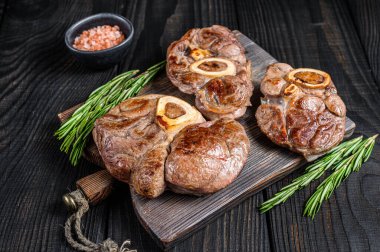 Osso buco dana incik bifteği, italyan ossobuco pişirdi. Siyah ahşap arka plan. Üst görünüm.