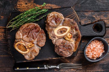 Osso Buco bifteği, İtalyan ossobuco bifteği. Koyu ahşap arka plan. Üst görünüm.