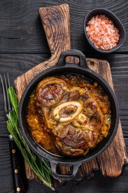 Dana budu, OssoBuco eti, İtalyan osso buco bifteği. Siyah ahşap arka plan. Üst görünüm.