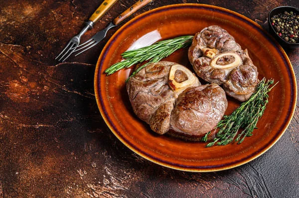 Carne cotta sull'osso Stinco di vitello Osso Buco, bistecca ossobuco italiana. Fondo in legno scuro. Vista dall'alto. Copia spazio — Foto Stock