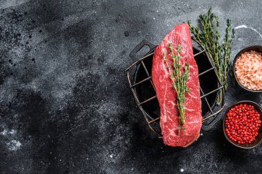 Izgarada çiğ Striploin bifteği, mermer biftek. Siyah arka plan. Üst Manzara. Boşluğu kopyala.