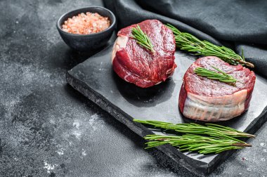 Filetodan kesilmiş iki parça ince biftek. Siyah arka plan. Üst Manzara. Boşluğu kopyala.