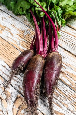 Organik mor pancar kökleri. Ahşap ışıklı arka plan. Üst görünüm.