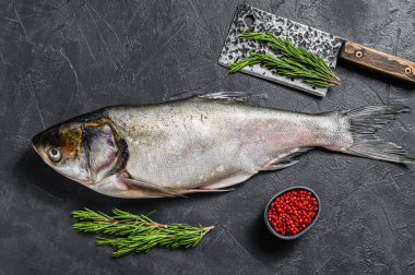 Çiğ balık gümüşü sazan balığı, pembe biber ve biberiye. Siyah arka plan. Üst görünüm.