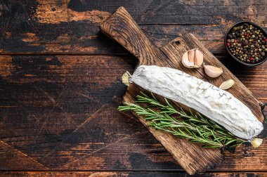 İspanyol kurutulmuş salçalı salamı kesme tahtasında. Koyu ahşap arka plan. Üst Manzara. Boşluğu kopyala.