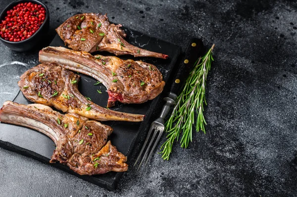 Barbecue Gebakken Lamsvlees Koteletten Een Marmeren Plank Zwarte Achtergrond Bovenaanzicht — Stockfoto