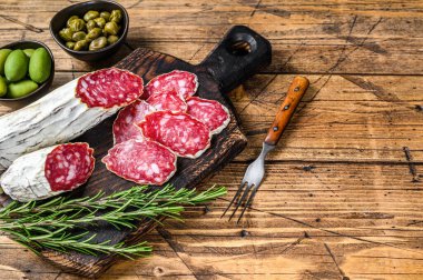 Tahta kesme tahtasının üzerinde ince dilimlenmiş salam salçamı. Ahşap arka plan. Üst Manzara. Boşluğu kopyala.