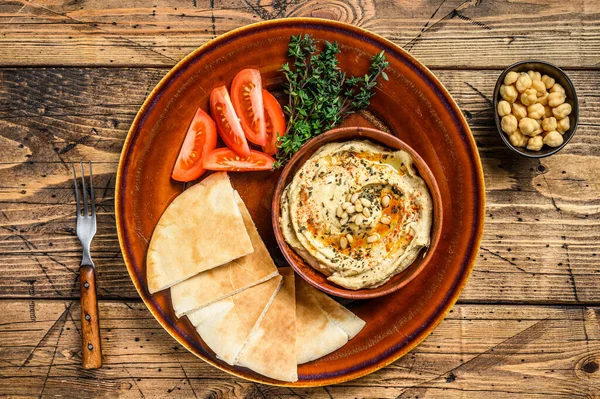 Świeży Hummus Chlebem Pita Pomidorem Pietruszką Rustykalnym Talerzu Drewniane Tło — Zdjęcie stockowe