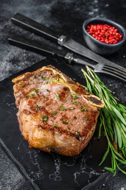 Kemiğe ızgara biftek ya da New York bifteği. Siyah arka plan. Üst görünüm.