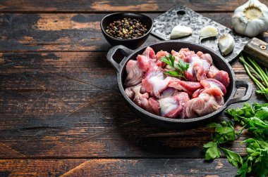 Çiğ tavuk sakatatı, tencere içinde mideler, çiğ tavuk sakatatı. Siyah ahşap arka plan. Üst Manzara. Boşluğu kopyala.