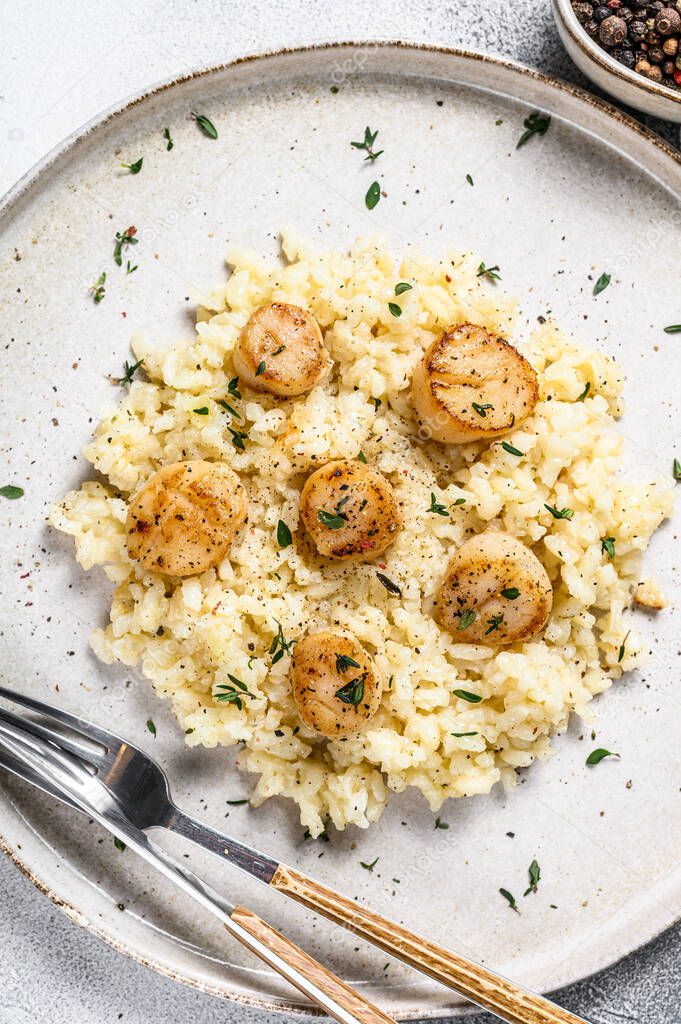 Italian Risotto with pan seared sea scallops. White background. Top view.