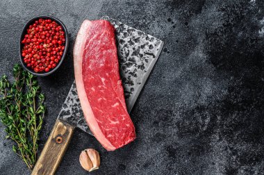 Kasap satırında çiğ sığır eti bifteği. Siyah arka plan. Üst Manzara. Boşluğu kopyala.