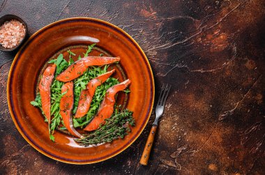Roka salatası ve füme somon filetosu. Karanlık arka plan. Üst Manzara. Boşluğu kopyala.