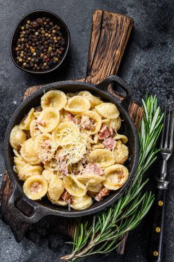 Pancetta, yumurta, sert parmesan peyniri ve krem soslu ev yapımı carbonara makarnası. Siyah arka plan. Üst görünüm.