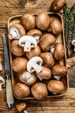 Çiğ mantarı kes kahverengi şampiyon. Ahşap arka plan. Üst görünüm