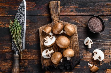 Raw Royal kahverengi şampiyon mantarlarını kes. Koyu ahşap arka plan. Üst görünüm