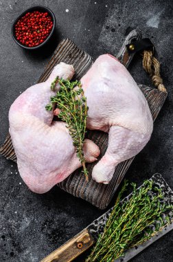 Kesme tahtasında taze çiğ tavuk bacağı. Siyah arka plan. Üst görünüm.