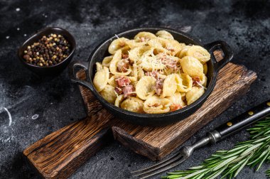 Pancetta, yumurta, sert parmesan peyniri ve krem soslu ev yapımı carbonara makarnası. Siyah arka plan. Üst görünüm.