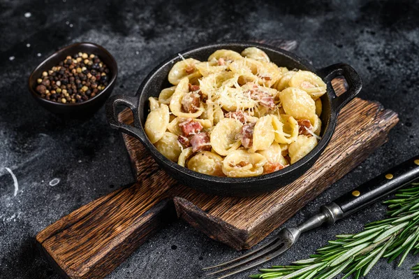Pancetta, yumurta, sert parmesan peyniri ve krem soslu ev yapımı carbonara makarnası. Siyah arka plan. Üst görünüm.