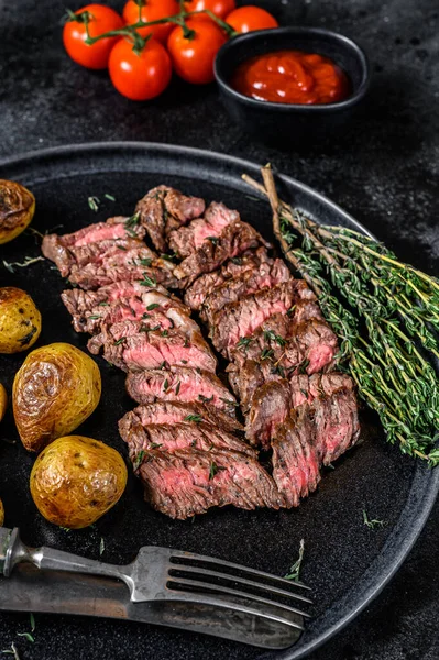 Viande de bœuf grillée sur le flanc Steak aux pommes de terre frites. Fond noir. Vue du dessus — Photo