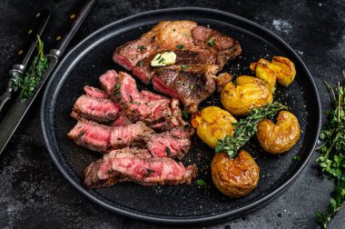 Izgara kaburga bifteği ve patates. Siyah arka plan. Üst görünüm