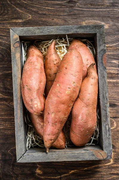 Patate douce crue sur table en bois. Fond en bois. Vue du dessus — Photo