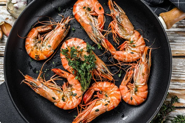 Tavada baharatlı ve limonlu ızgara karides. Beyaz ahşap arka plan. Üst görünüm