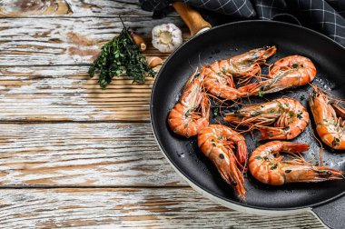 Tavada baharatlı ve limonlu ızgara karides. Beyaz ahşap arka plan. Üst Manzara. Boşluğu kopyala