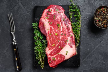 Çiğ organik Chuck göz yuvarlamalı biftek dilimleri. Siyah arka plan. Üst görünüm