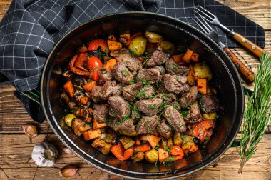 Patates, havuç ve otlu sığır eti güveci. Ahşap arka plan. Üst görünüm