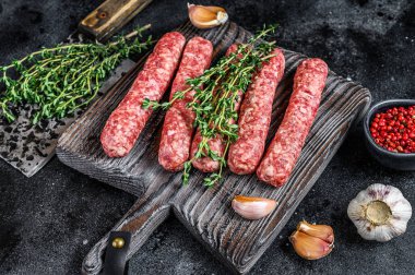 Kesme tahtasında taze çiğ et kebabı sosis. Siyah arka plan. Üst görünüm.