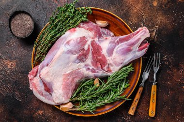 Tabakta taze çiğ keçi eti. Koyu ahşap arka plan. Üst görünüm.