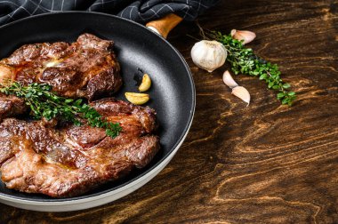 Izgara mermer biftekler tavada Chuck 'ın gözleri yuvarlanıyor. Koyu ahşap arka plan. Üst Manzara. Boşluğu kopyala