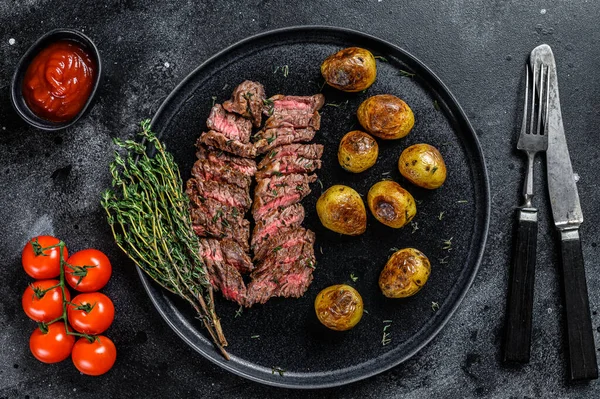 Bokový grilovaný hovězí steak se smaženými bramborami. Černé pozadí. Horní pohled — Stock fotografie