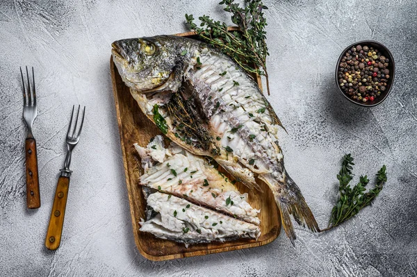 Cut baked sea bream dorado fish in a wooden tray. White background. Top view — Stock Photo, Image