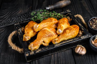 Tütsülenmiş tavuk budu bagetleri ve baharatlar. Siyah ahşap arka plan. Üst görünüm