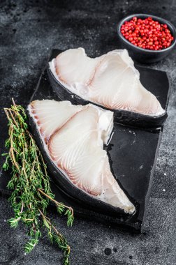 Tahtada çiğ köpekbalığı bifteği. Siyah arka plan. Üst görünüm