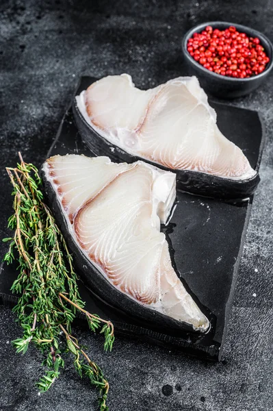 Tahtada çiğ köpekbalığı bifteği. Siyah arka plan. Üst görünüm