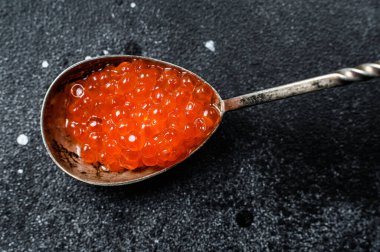 Bir kaşık enfes kırmızı havyar. Siyah arka plan. Üst görünüm