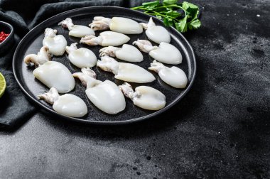 Biberiye ve maydanozlu taze mürekkep balığı. Siyah arka plan. Üst Manzara. Boşluğu kopyala