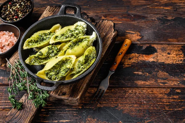 Jumbo conchiglie pasta italiana Conchiglioni konkiloni ripieni di carne di manzo e spinaci. Sfondo in legno. Vista dall'alto. Copia spazio — Foto Stock