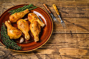 Kırsal bir tabakta taze tütsülenmiş tavuk budu ve otlar. Ahşap arka plan. Üst Manzara. Boşluğu kopyala