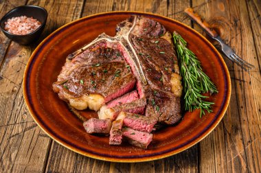 Barbekü rosto ya da sığır eti bifteği kırsal bir tabakta. Ahşap arka plan. Üst görünüm