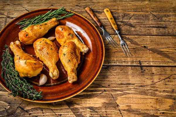 Kırsal bir tabakta taze tütsülenmiş tavuk budu ve otlar. Ahşap arka plan. Üst Manzara. Boşluğu kopyala