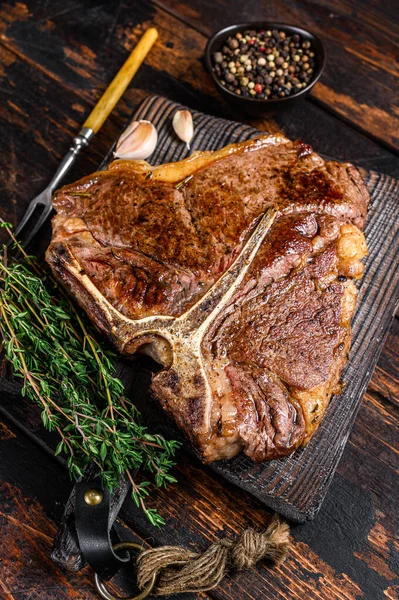 Pečené t-bone nebo porterhouse hovězí maso Steak na dřevěné řezací desce. Tmavé dřevěné pozadí. Horní pohled — Stock fotografie